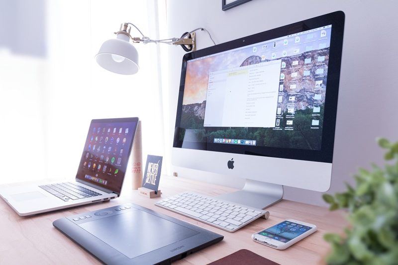 monitor and laptop on wood desk