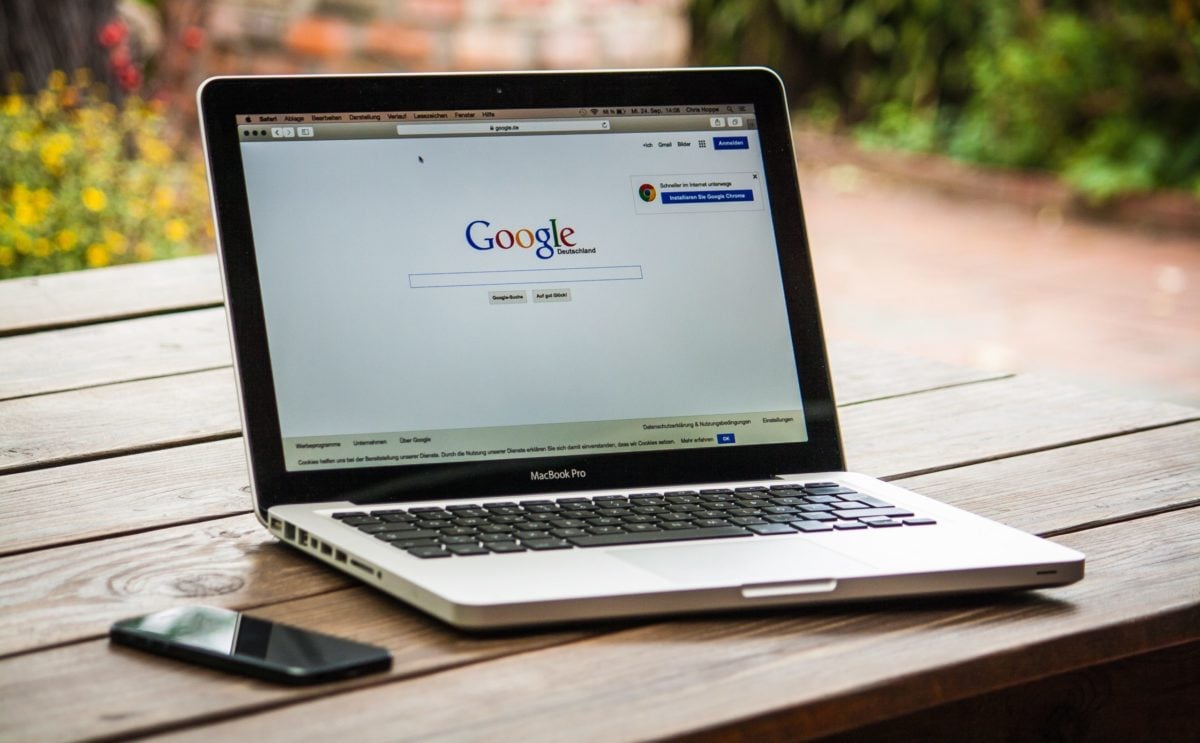 google search on laptop sitting on wood table