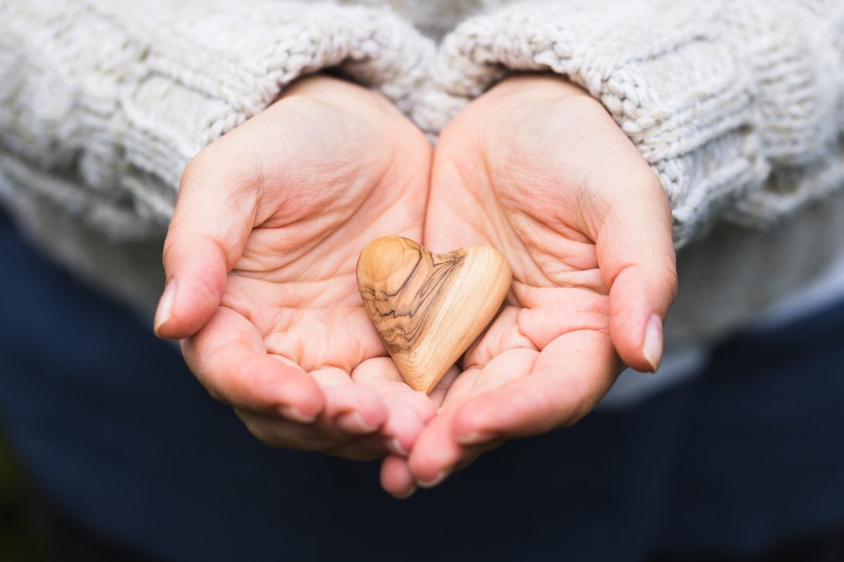 hands holding wooden heart