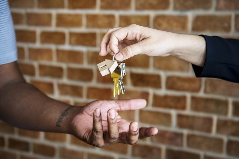 real estate person handing another person house keys