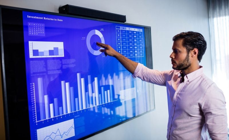 business man analyzing data on touchscreen