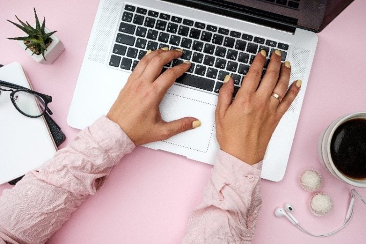 women drinks coffee and works on laptop