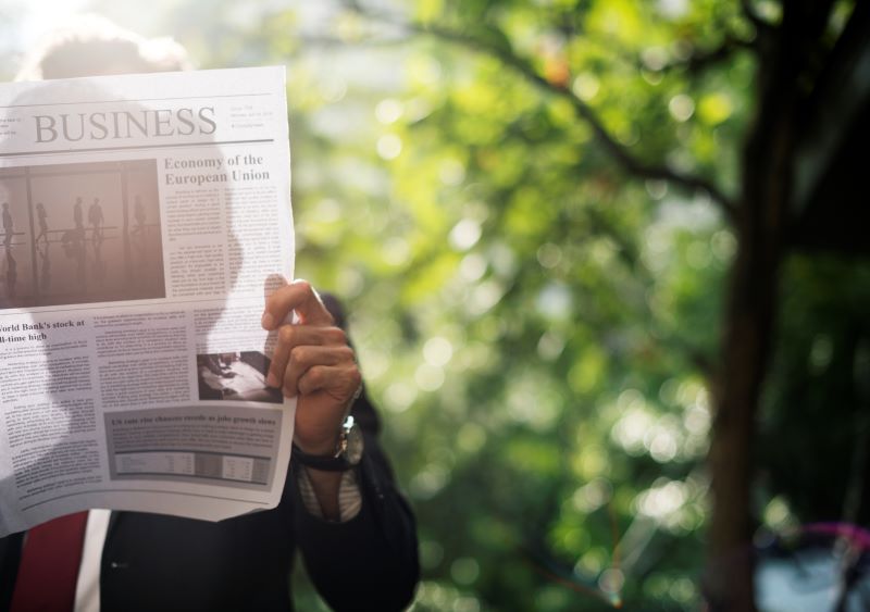 man is reading local newspapers