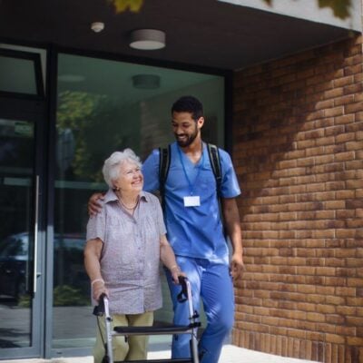 caregiver walking with senior woman