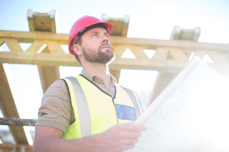 construction worker holding plan at construction site