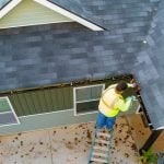a worker is cleaning gutter drain