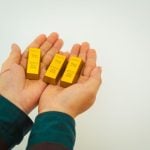 businessman holding shiny gold bars