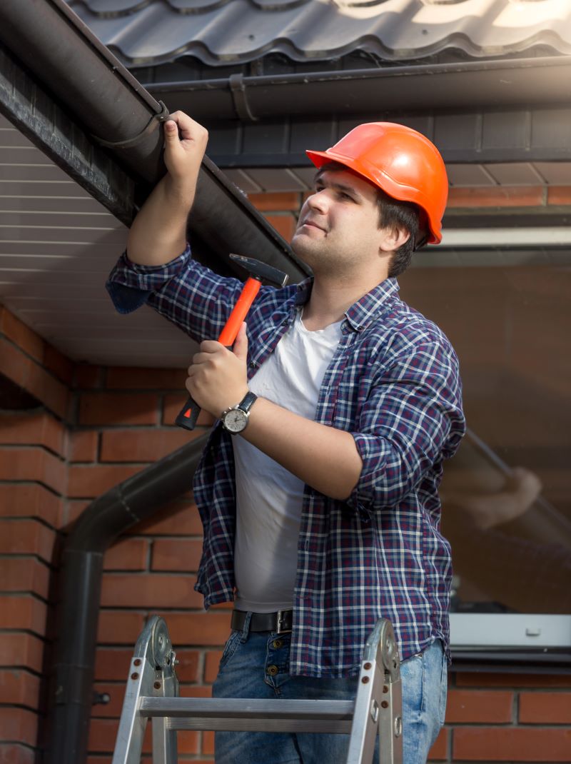 man works on the gutter