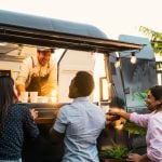 young people buying meal from street food truck