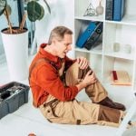 repairman holding injured knee
