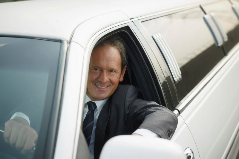 driver in limousine smiling
