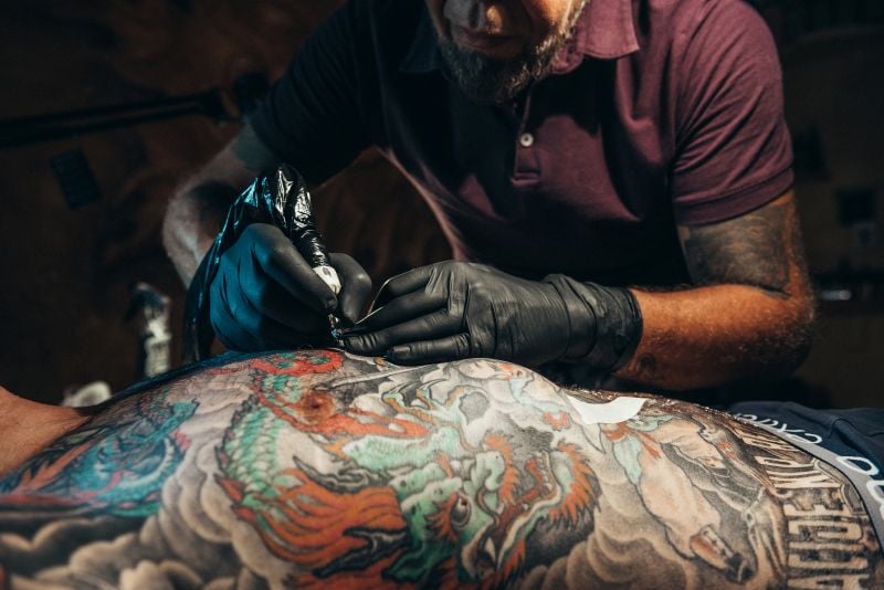 tattoo artist hands wearing black gloves